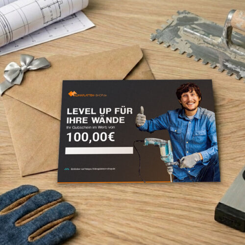 Renoviergutschein neben Umschlag und Bauwerkzeug auf Holzuntergrund